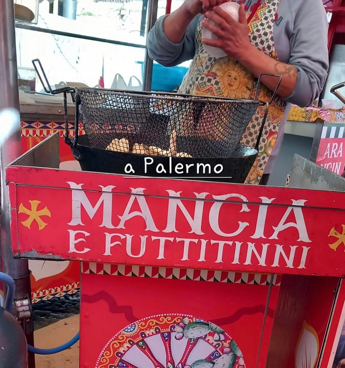 Arancini being fried street-side in Palermo at a traditional red Sicilian cart